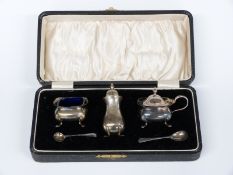George V hallmarked silver three piece cruet set with blue glass liner, Birmingham 1922/24 maker