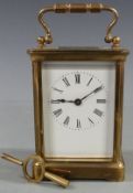 Early twentieth century brass carriage clock in corniche style case, with white enamel dial and