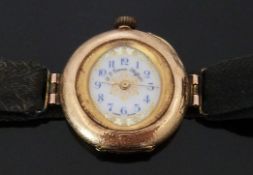 A 14ct gold ladies wristwatch converted from a pocket watch, with gilt decorated white enamel