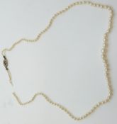 A single strand of pearls with 18ct gold clasp set with an emerald and diamonds