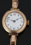 A 9ct gold ladies wristwatch with blued hands, Arabic numerals, white enamel dial and Swiss movement