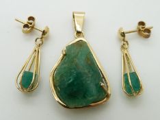 An 18ct gold pendant set with a rough emerald, with matching earrings