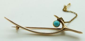 A 15ct gold brooch in the form of a wishbone set with turquoise, 3.75g