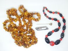 A glass beaded necklace, Art Deco paste brooch and an amber necklace