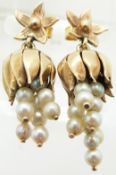 A pair of gold earrings set with pearls on drop sections