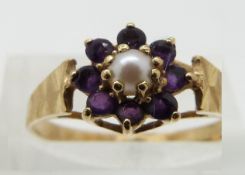 A 14ct gold ring set with a pearl surrounded by amethysts, size M/N