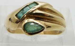 A 14ct gold ring set with emeralds in a stylized snake design, size K/L