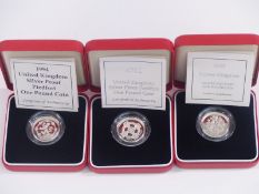 Three cased Royal Mint silver proof Piedfort one pound coins, 1994, 2001 and 2002, with