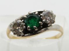 An 18ct gold ring set with an emerald and two diamonds, each approximately 0.3ct, in a platinum