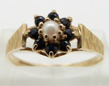 A 9ct gold ring set with a pearl surrounded by sapphires, size R