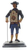 A vintage clock in the form of a man with walking stick holding clock weights
