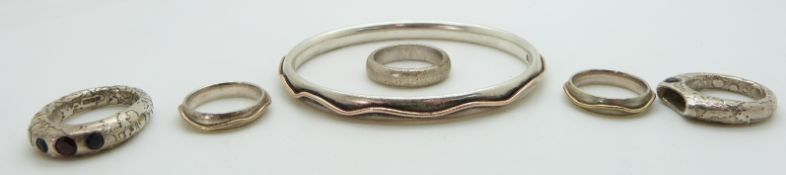 A silver bangle with gold decoration and two matching rings and two designer /bespoke rings by Donna