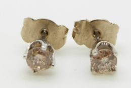 A pair of 14k white gold earrings each set with a round cut diamond of approximately 0.2ct