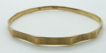 A 9ct gold flapper bangle with engine turned decoration,15.2g