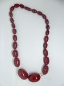 A cherry amber necklace made up of graduated oval beads, 66g