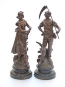 A pair of French bronzed spelter figures of farm workers both with brass plaques to base 