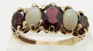 A 9ct gold ring set with oval cut garnets and opal cabochons, size N