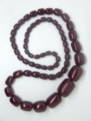 A large cherry amber necklace made up of graduated barrel shaped beads, 120g