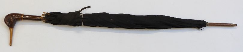 A late 19thC/20thC parasol with carved figural duck handle, plated collar, rosewood shaft, and