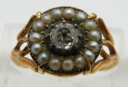 An early Victorian ring set with an old cut diamond of approximately 0.35ct surrounded by seed