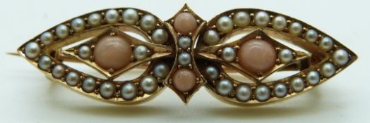 A Victorian yellow metal brooch set with coral and seed pearls in two tear shapes