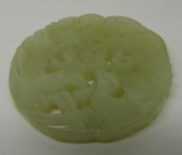 A Chinese carved and pierced jade plaque with bird and foliage decoration, diameter 5cm