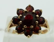 A 9ct gold ring set with garnets in a cluster, size N