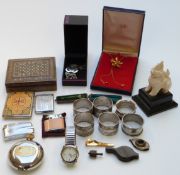 A collection of items including a Vizagapatam box, a carved figure, napkin rings, a Ronson lighter
