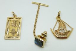 A 14ct gold Chinese pendant (4g) and a yellow metal boat pendant (3.2g)