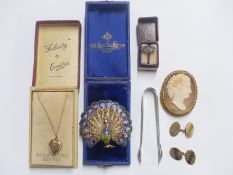 A large filigree brooch in the form of a peacock with gilt and enamel decoration, silver tongs by