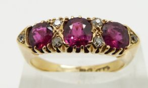 An 18ct gold ring set with three cushion cut rubies and six diamonds, size P