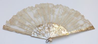 A 19thC mother of pearl and lace fan, the ornate pierced decoration set with white metal and gilt
