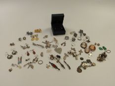 A quantity of silver and white metal jewellery to include earrings, Siam brooch, charms, rings,