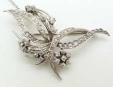 A platinum brooch in a stylised floral/foliate design set with diamonds