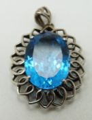 A 9ct white gold pendant in the form of a stylized flower set with blue topaz