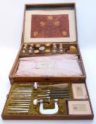 A late 19thC/early 20thC French leather embossing kit in original wooden fitted case with lift out