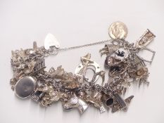 A vintage hallmarked silver and white metal charm bracelet including approximately 40 charms