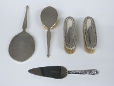 Hallmarked silver mounted engine-turned hand-mirror and brush, two further silver-mounted brushes