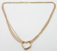 A 9ct gold triple strand necklace with a heart pendant, 3.1g