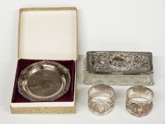 A boxed feature hallmarked silver dish, pair of hallmarked silver napkin rings and a silver lidded