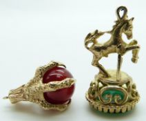 Two 9ct gold charms, one a claw set with an agate sphere, and a fob depicting a horse jumping a gate