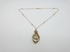A 19thC pendant set with a natural pearl in an abstract shape and a 9ct rose gold beaded chain