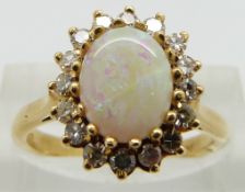 An 18ct gold ring set with an opal cabochon and diamonds, size N