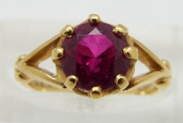 An 18ct gold ring set with a round cut synthetic ruby, size H