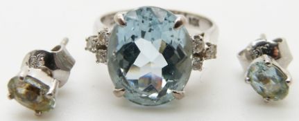 A 14k white gold ring set with an oval mixed cut aquamarine and three diamonds to each shoulder
