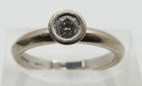 An 18ct white gold ring set with a round cut diamond of approximately 0.25ct, size N