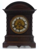 C1900 Carved Oak and Mahogany cased mantel clock, the white Roman chapter ring with central