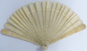 A 19thC Chinese ivory fan of 20 sticks, each with carved decoration of figures, village scenes