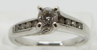 An 18ct white gold ring set with a round cut diamond of approximately 0.25ct with diamond