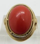 A 9ct gold ring set with a coral cabochon, size K